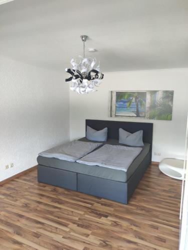 1 dormitorio con cama y lámpara de araña en Ferienwohnung Dobberzin nahe Mündesee, en Angermünde