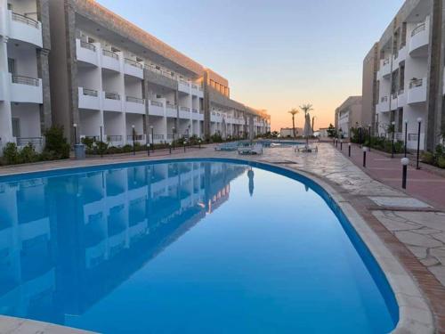 uma grande piscina em frente a um edifício em Cecilia Beach Resort em Hurghada