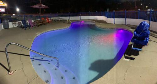 una piscina por la noche con un arco iris en Log Cabin Inn, en Bay Minette