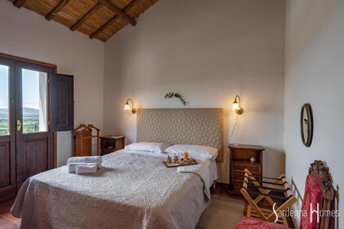 Un dormitorio con una cama grande y una ventana en Sardegna Homes Casa Rosa, en Badesi