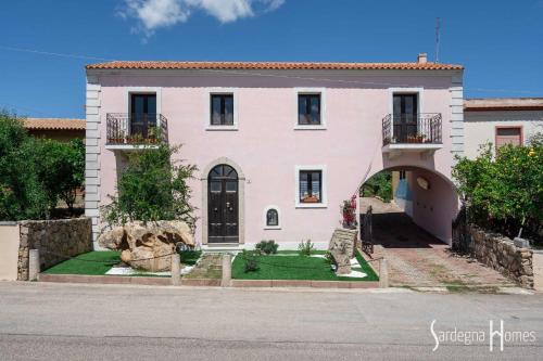 una gran casa blanca con un jardín delante de ella en Sardegna Homes Casa Rosa, en Badesi