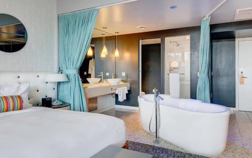 a bedroom with a bed and a tub and a sink at Hotel Valley Ho in Scottsdale