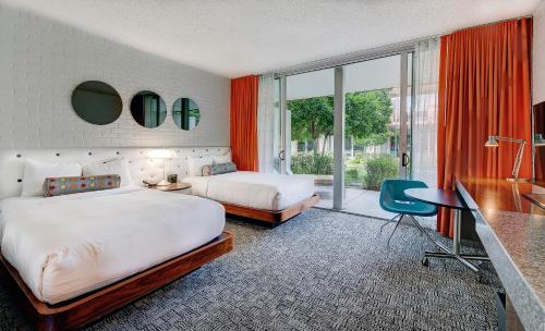 a hotel room with two beds and a desk and a window at Hotel Valley Ho in Scottsdale