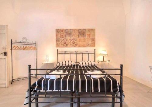 タヴィアーノにあるLa Dimora della Querciaの壁に絵画が描かれたベッドルームの金属製ベッド1台