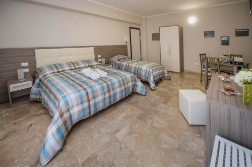 a hotel room with two beds and a desk at B&B Il Risveglio del Cavaliere in Gioia dei Marsi