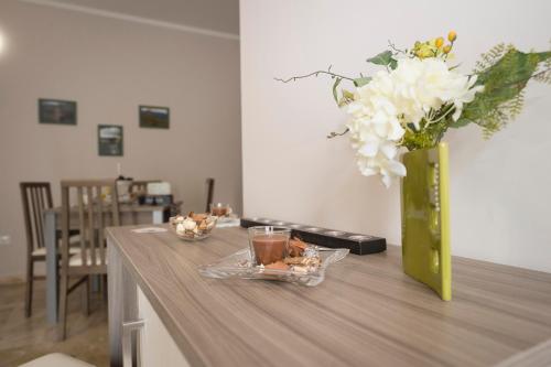 a vase with white flowers on a wooden table at B&B Il Risveglio del Cavaliere in Gioia dei Marsi