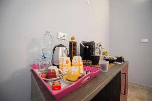 a counter with a pink tray with food on it at B&B Il Risveglio del Cavaliere in Gioia dei Marsi
