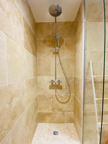 une salle de bain avec une douche avec une porte vitrée dans l'établissement Feel@Home Nemausus « Le 11 », à Nîmes