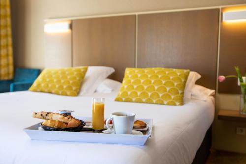 a tray of food on a bed with two beds at Hotel Amiraute in Cannes