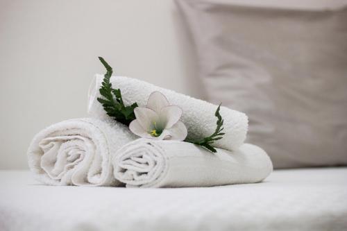 uma pilha de toalhas com uma flor em cima em Hotel Caraibi em Rimini