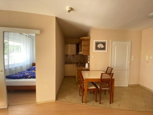 a kitchen and dining room with a table and a bed at Apartament Reymonta przy morzu in Kołobrzeg