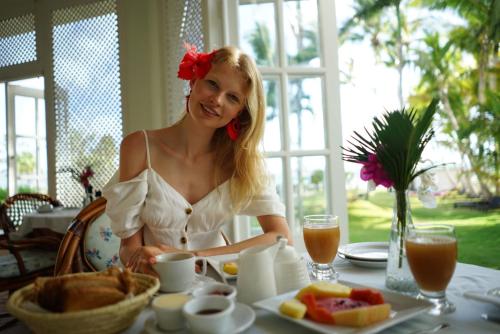 a woman sitting at a table with a plate of food at Hotel Villa Serena in Las Galeras