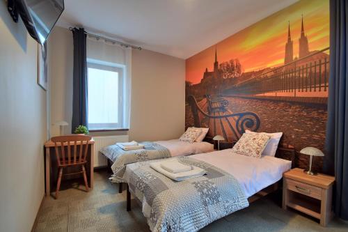 Dos camas en una habitación con un cuadro en la pared. en Aparthotel Globus - bezkontaktowa obsługa, en Łódź