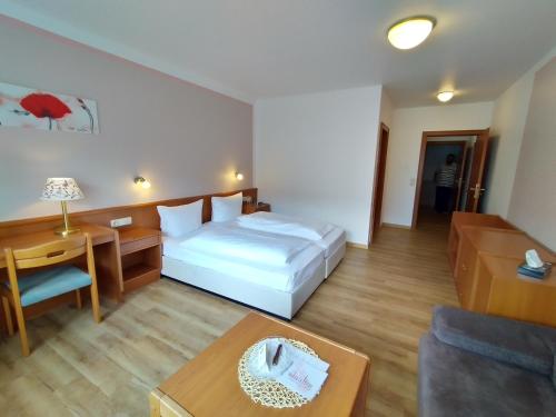 a hotel room with a bed and a table at Hotel Faller in Breitnau