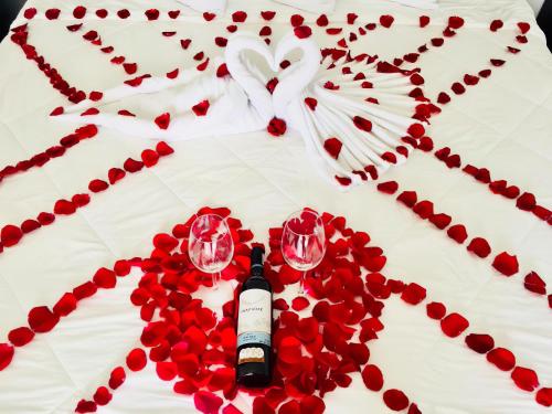 a table topped with wine glasses and red roses at Hotel Awazul Bacalar in Bacalar