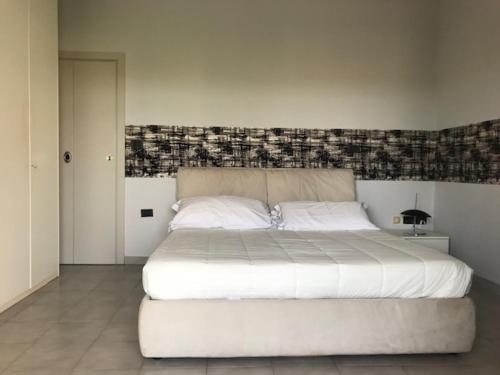una camera da letto con un grande letto bianco con testiera del letto di Attico mare Rimini a Rimini