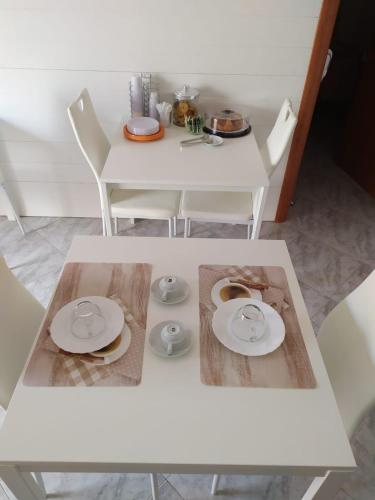 a white table and chairs with plates on it at Allegra B&B in Terracina