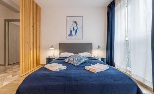 - une chambre avec un lit bleu et des serviettes dans l'établissement BierzCzadowy Apartament, à Ustrzyki Dolne