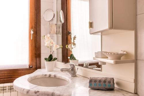ein Bad mit einem Waschbecken und einem Spiegel in der Unterkunft Vivaldi in Venedig