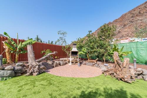 a garden with a bird feeder in the grass at Sol Mogan Suites - Adults Only in Puerto de Mogán