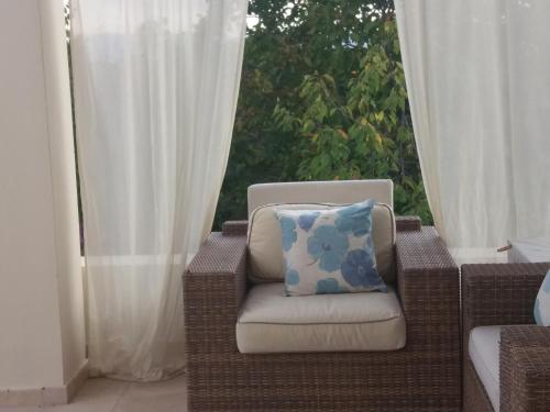 una silla de mimbre con una almohada sentada frente a una ventana en Villa Koumneni, en Pano Akourdalia