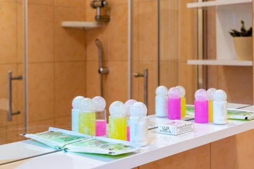 a bathroom counter with bottles of disinfectants on it at Hotel Porat in Neum