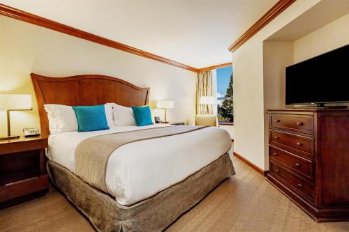 a bedroom with a large bed and a flat screen tv at Everline Resort and Spa, Lake Tahoe in Olympic Valley