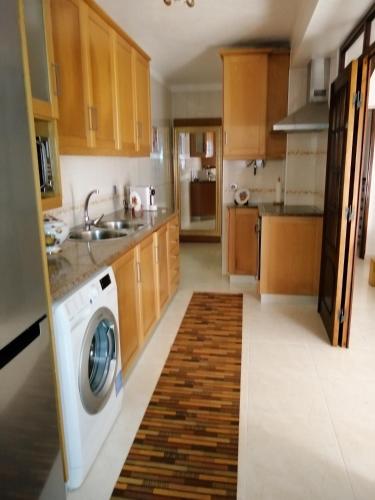 a kitchen with a washing machine in the middle at apartamentos lazarino1 in Nazaré
