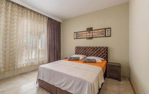 a bedroom with a bed with an orange blanket and a window at Villa Ancora in Savudrija