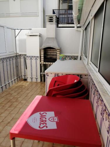 a red table and chairs in a room at apartamentos lazarino1 in Nazaré