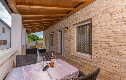 patio con mesa, sillas y pared de ladrillo en Villa Ancora en Savudrija