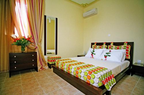 a bedroom with a bed and a dresser and a mirror at PIERIDES SUITES in Kardamyli