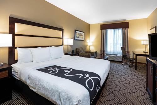a hotel room with a bed and a television at La Quinta by Wyndham Auburn in Auburn