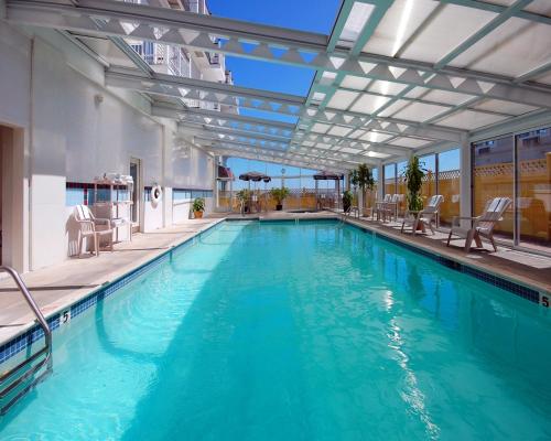 a swimming pool with blue water in a building at Nantasket Beach Resort in Hull