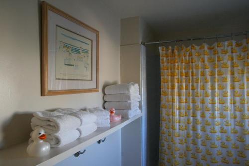 a bathroom with towels on a shelf and a shower at The Tides Laguna Beach in Laguna Beach