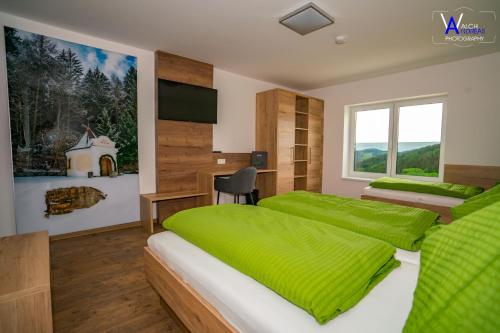 een slaapkamer met 2 bedden en groene lakens bij Gästehaus Weitblick in Sankt Leonhard bei Freistadt