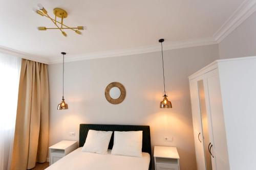 a bedroom with a bed with two tables and two lights at Maniu 31 Apartments & Rooms in Oradea