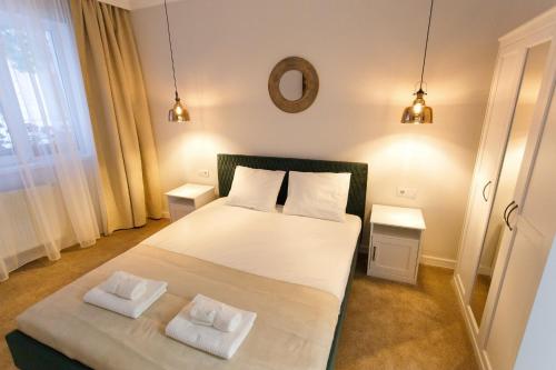a bedroom with a large bed with two white pillows at Maniu 31 Apartments & Rooms in Oradea