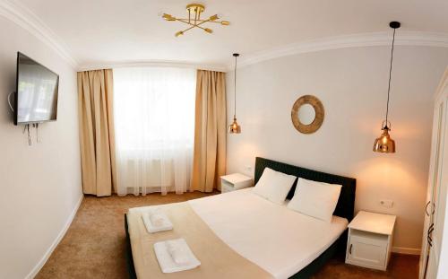a bedroom with a white bed and a window at Maniu 31 Apartments & Rooms in Oradea