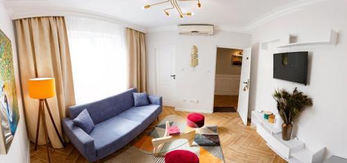 a living room with a blue couch and a tv at Maniu 31 Apartments & Rooms in Oradea