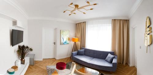 a living room with a blue couch and a tv at Maniu 31 Apartments & Rooms in Oradea