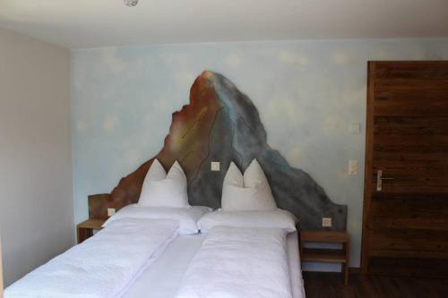 two beds in a bedroom with a painting on the wall at Matterhorn 2.5 Zimmerwohnung in Zermatt