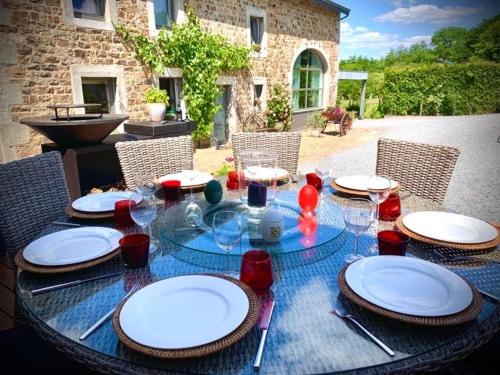 a table with plates and glasses on top of it at L'Hoursinne in Érezée