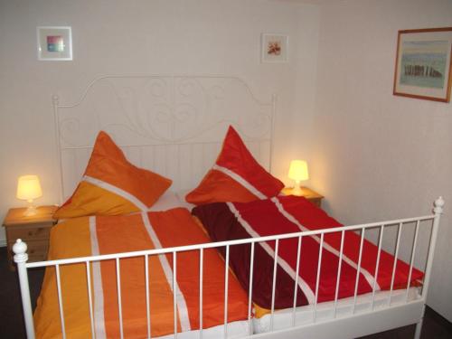 ein Bett mit orangefarbenen und orangefarbenen Kissen darauf in der Unterkunft Ostseeurlaub-Barth in Barth