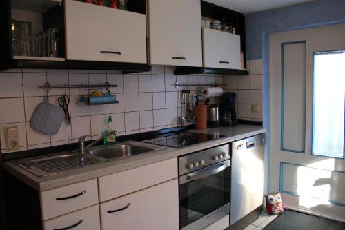 a kitchen with white cabinets and a sink at Ostseeurlaub-Barth in Barth