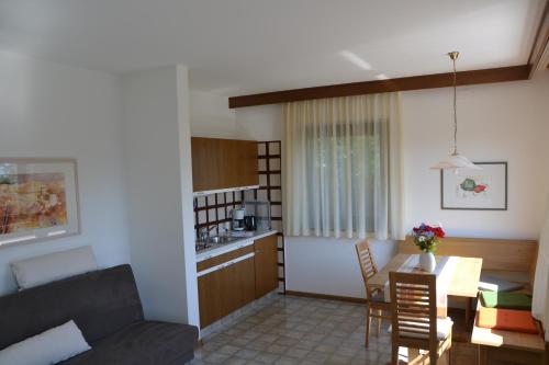 a living room and kitchen with a couch and a table at Haus Marion in Appiano sulla Strada del Vino