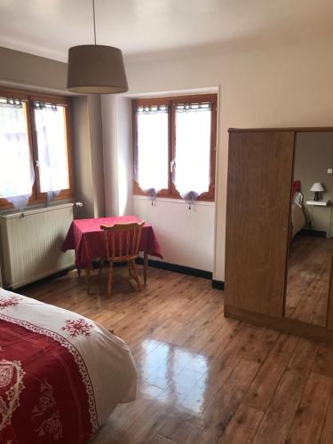 a bedroom with a table and a mirror and a bed at La Condaminoise in Condamine-Châtelard