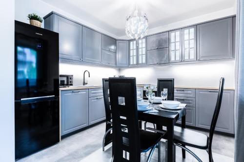 a kitchen with a black table and chairs in it at Nosal Hill Apartments&Spa in Zakopane