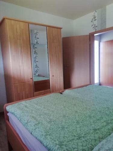 a bedroom with a bed and wooden cabinets at Meyers Ferienwohnung in Elmlohe