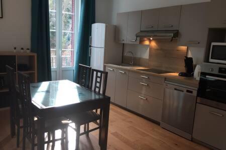 - une cuisine avec une table, une table et des chaises dans l'établissement Magnifique et lumineux appartement au cœur du Sancy, à Saint-Nectaire